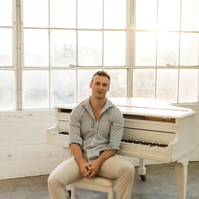 Austin Farwell at his white grand piano